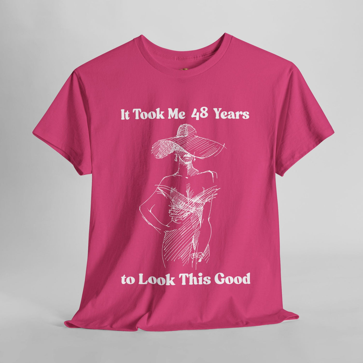Elegant women's t-shirt with "It Took Me to Look This Good" slogan, featuring minimalist sketch of a woman in a hat, on a pink background.