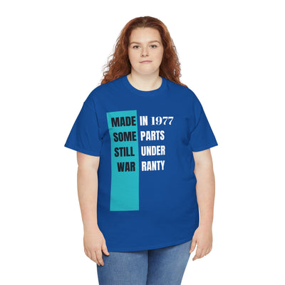 Humorous "Made In Some Parts Still Under Warranty" aging t-shirt, featuring retro design, blue color, worn by a woman. Ideal birthday gift.