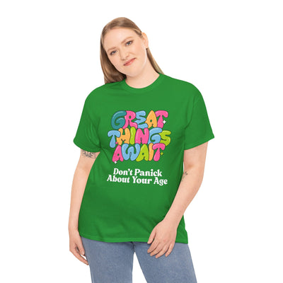 Positive vibes "Great Things Await, Don't Panic About Your Age" t-shirt in green, featuring colorful font design for encouragement and anti-aging humor.
