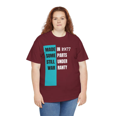 Funny aging t-shirt with "Made In Some Parts Still Under Warranty" slogan, vintage style, humorous birthday gift for men and women.