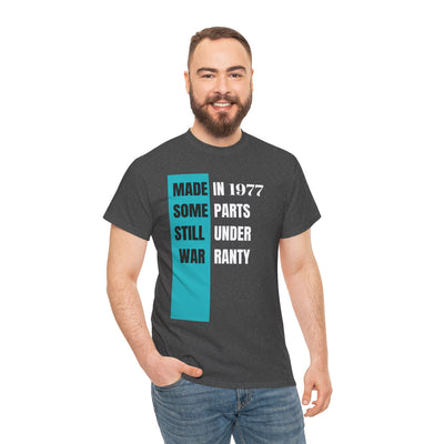 Funny aging t-shirt with "Made In Some Parts Still Under Warranty" slogan in vintage style. Ideal humorous birthday gift.