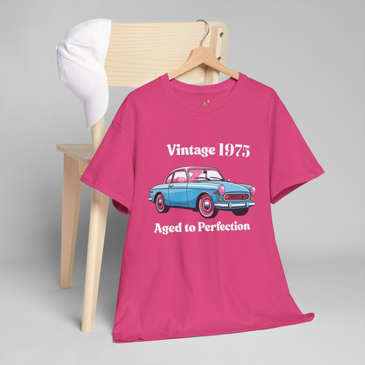 Vintage 1975 Aged to Perfection T-shirt with retro car graphic, pink background.