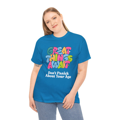 Positive vibes t-shirt with "Great Things Await - Don't Panic About Your Age" message, colorful design, worn by model.
