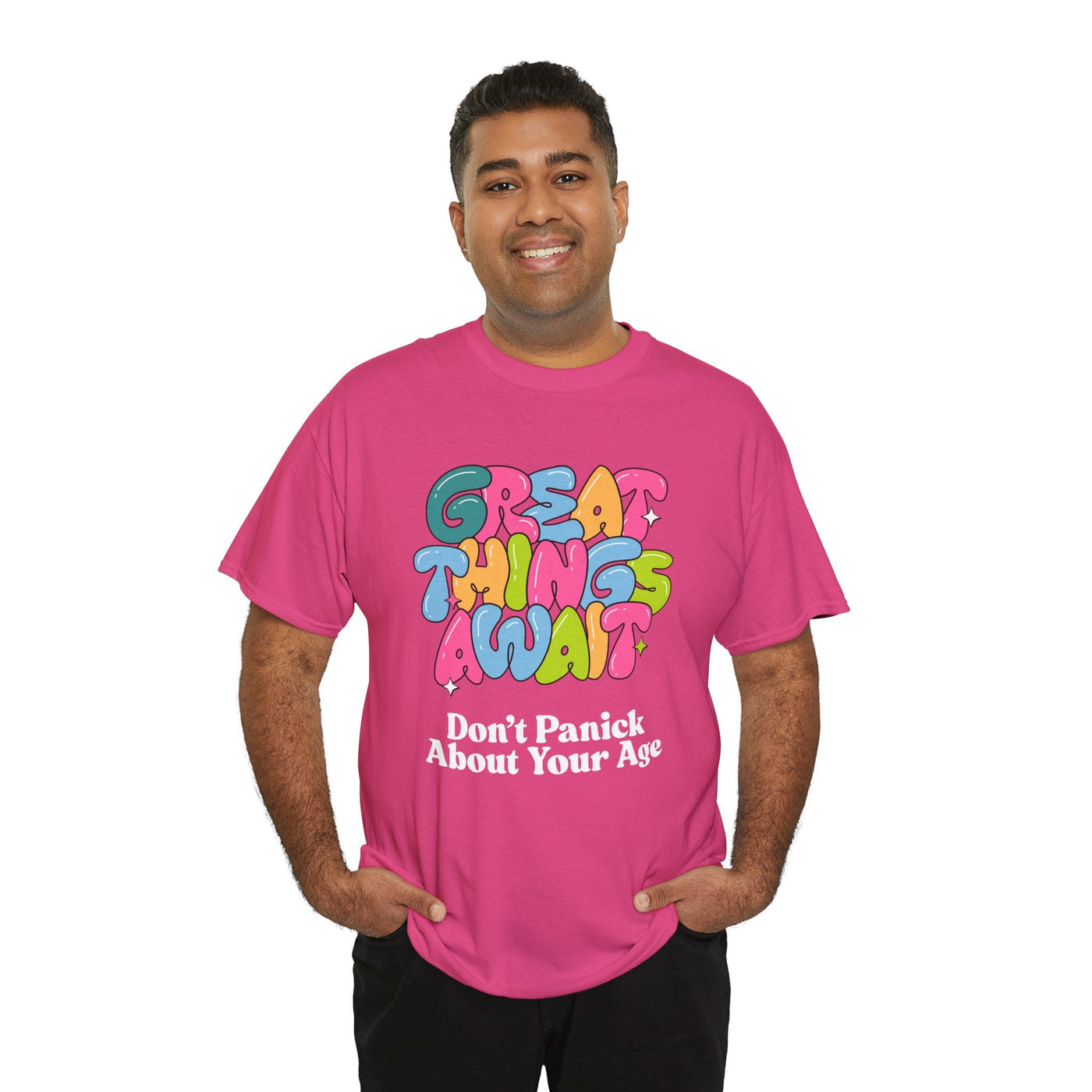 Pink t-shirt with "Great Things Await, Don't Panic About Your Age" in colorful, bubbly font for positive vibes and encouragement.
