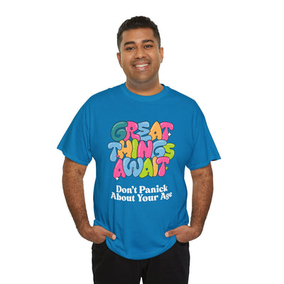 Blue t-shirt with "Great Things Await, Don't Panic About Your Age" phrase in colorful, bubbly font, emphasizing positive vibes and anti-aging humor.