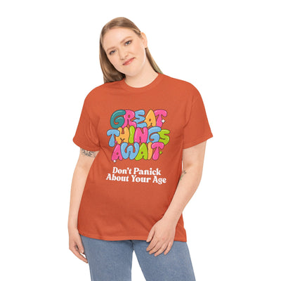 Positive vibes t-shirt with "Great Things Await, Don't Panic About Your Age" message in colorful, bubbly font.